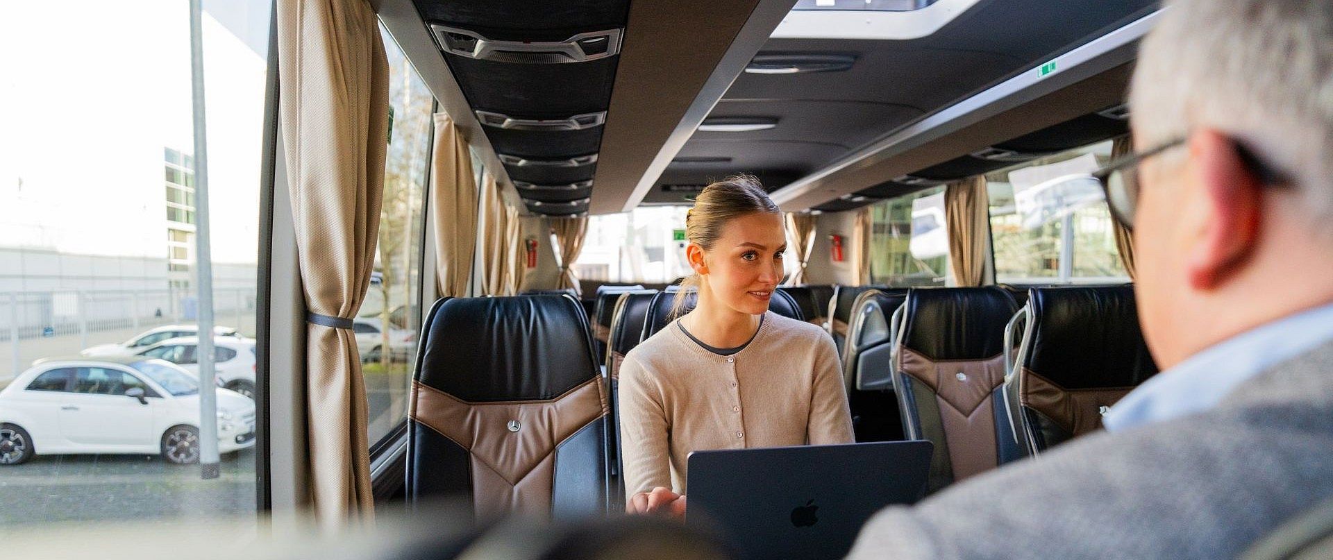Fahrgäste im Bus auf dem Weg zum Flughafen.
