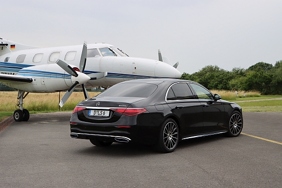 Eine Frau sitzt lächelnd in einer Business-Limousine.